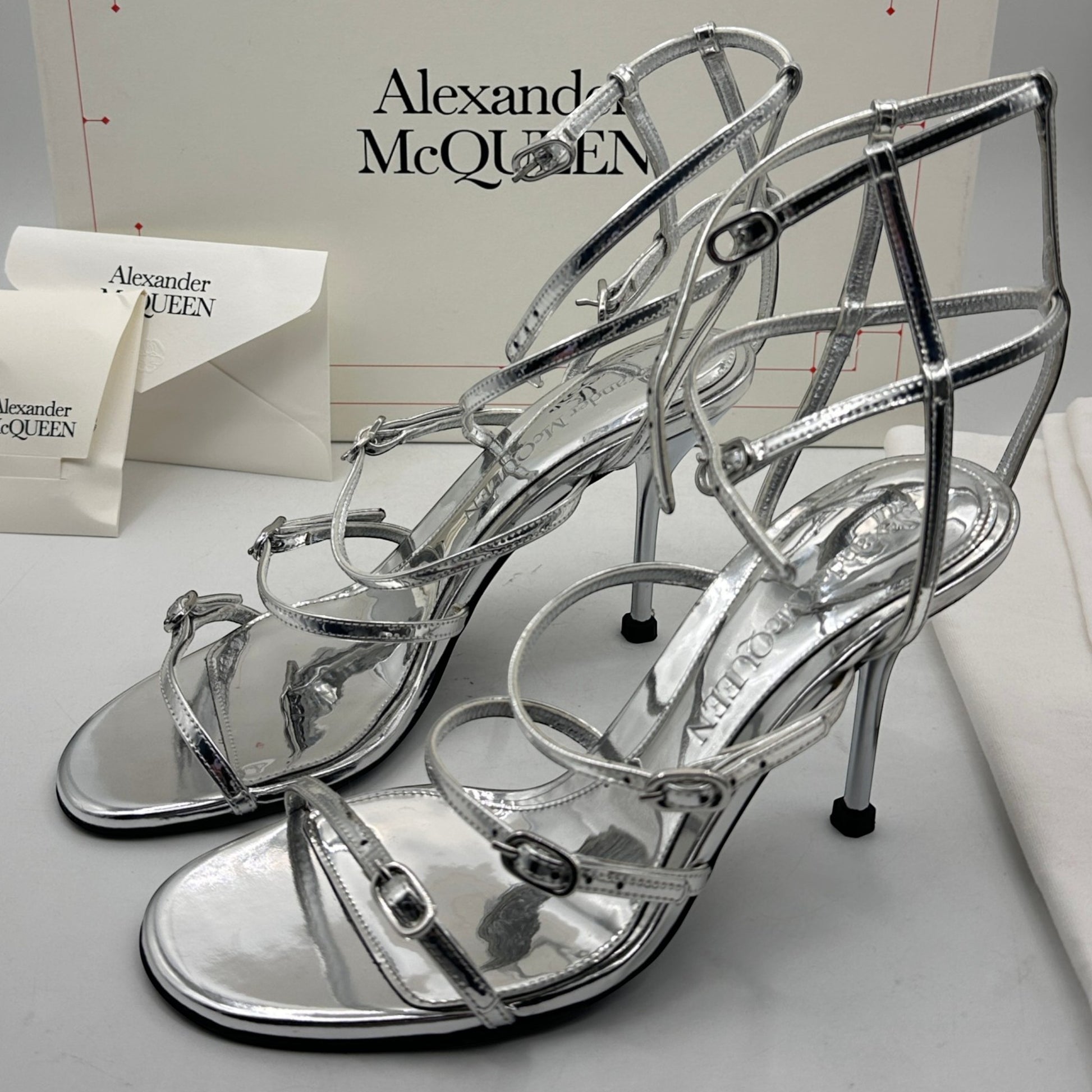 Alexander McQueen · luxury shoes · silver heels · stiletto · strappy sandals · designer footwear · prabangūs bateliai · second hand luxury · McQueen original · metallic sandals · Made in Italy · aukštakulniai · vestuviniai bateliai · vakariniai bateliai
Alexander McQueen silver sandals strappy heels stiletto sandals luxury shoes designer heels metallic sandals McQueen original box second hand luxury wedding heels evening sandals open toe heels buckle sandals Made in Italy